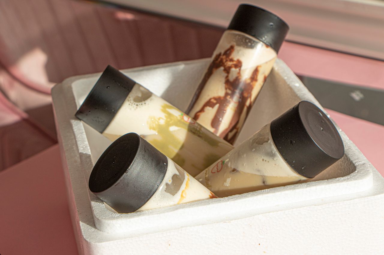 Close-up of various sauces in plastic bottles arranged in a white container, ideal for culinary themes.